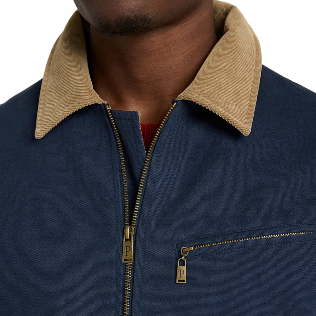 Navy blue jacket with beige collar and gold zipper on a neutral background