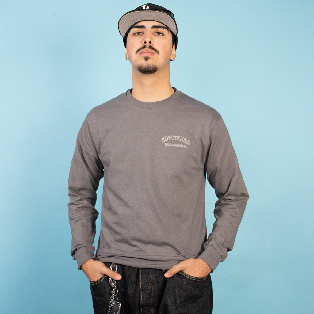 Man wearing a gray long-sleeve shirt with a logo on a light blue background