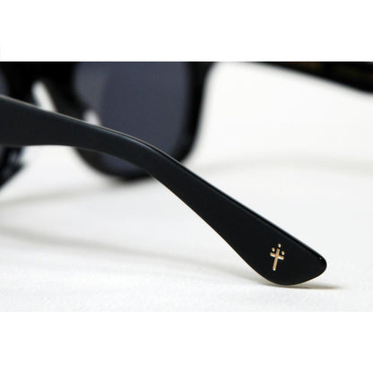 Black sunglasses with a gold logo on a white background