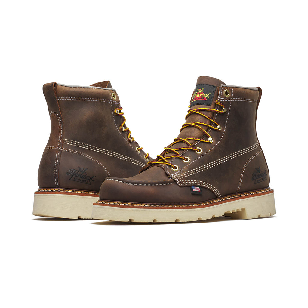 Pair of brown leather boots with yellow laces on a white background