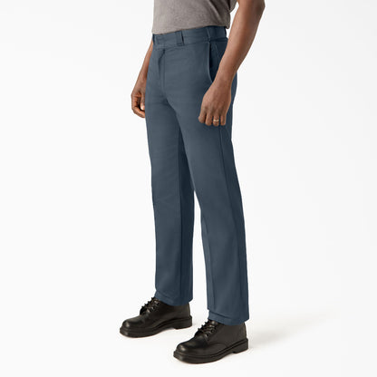Person wearing blue pants and black shoes on a white background