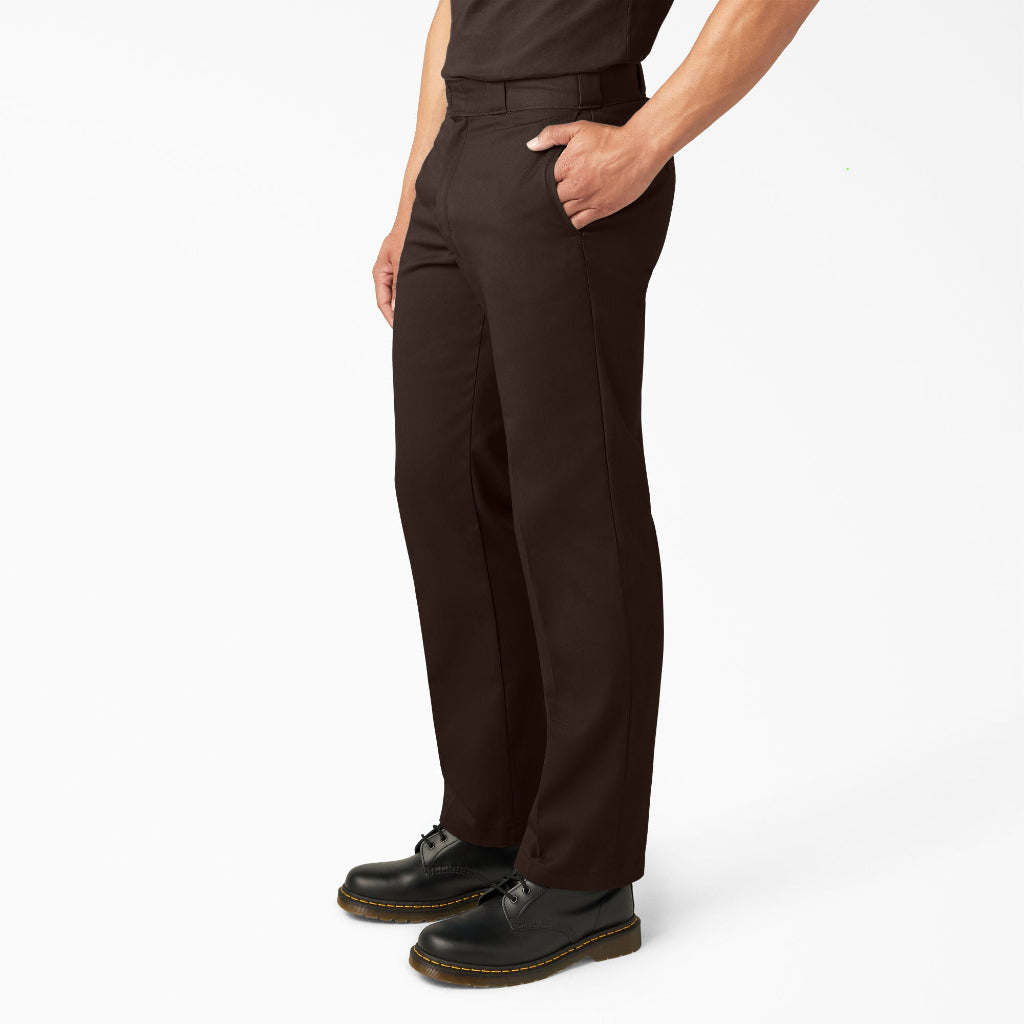 Person wearing dark brown pants and black shoes on a white background