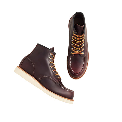 Pair of brown leather boots with white soles on a white background