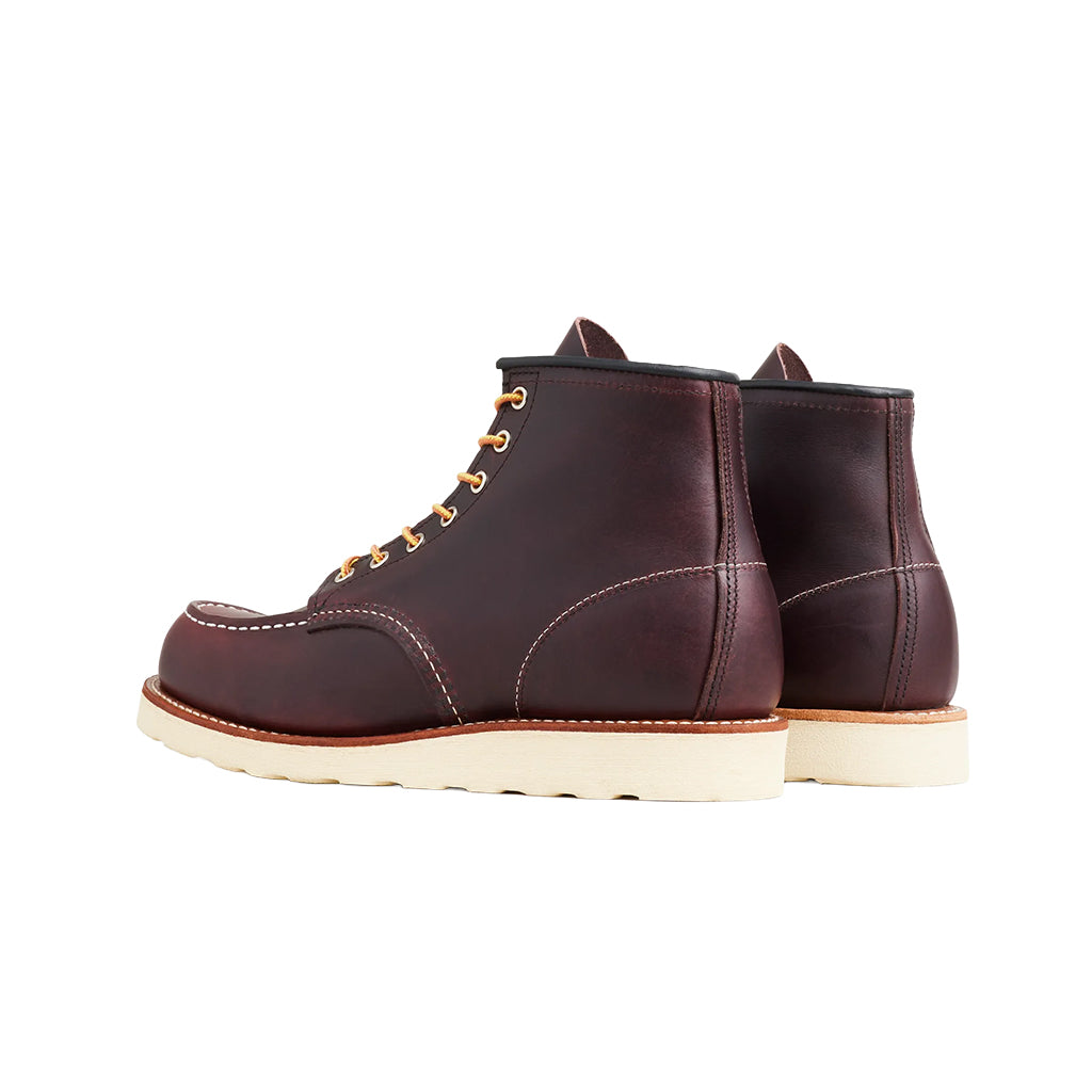 Pair of brown leather boots with white soles on a white background