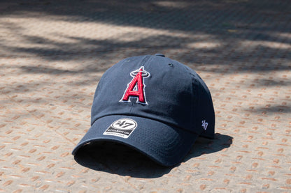 Navy blue baseball cap with a logo on a textured surface