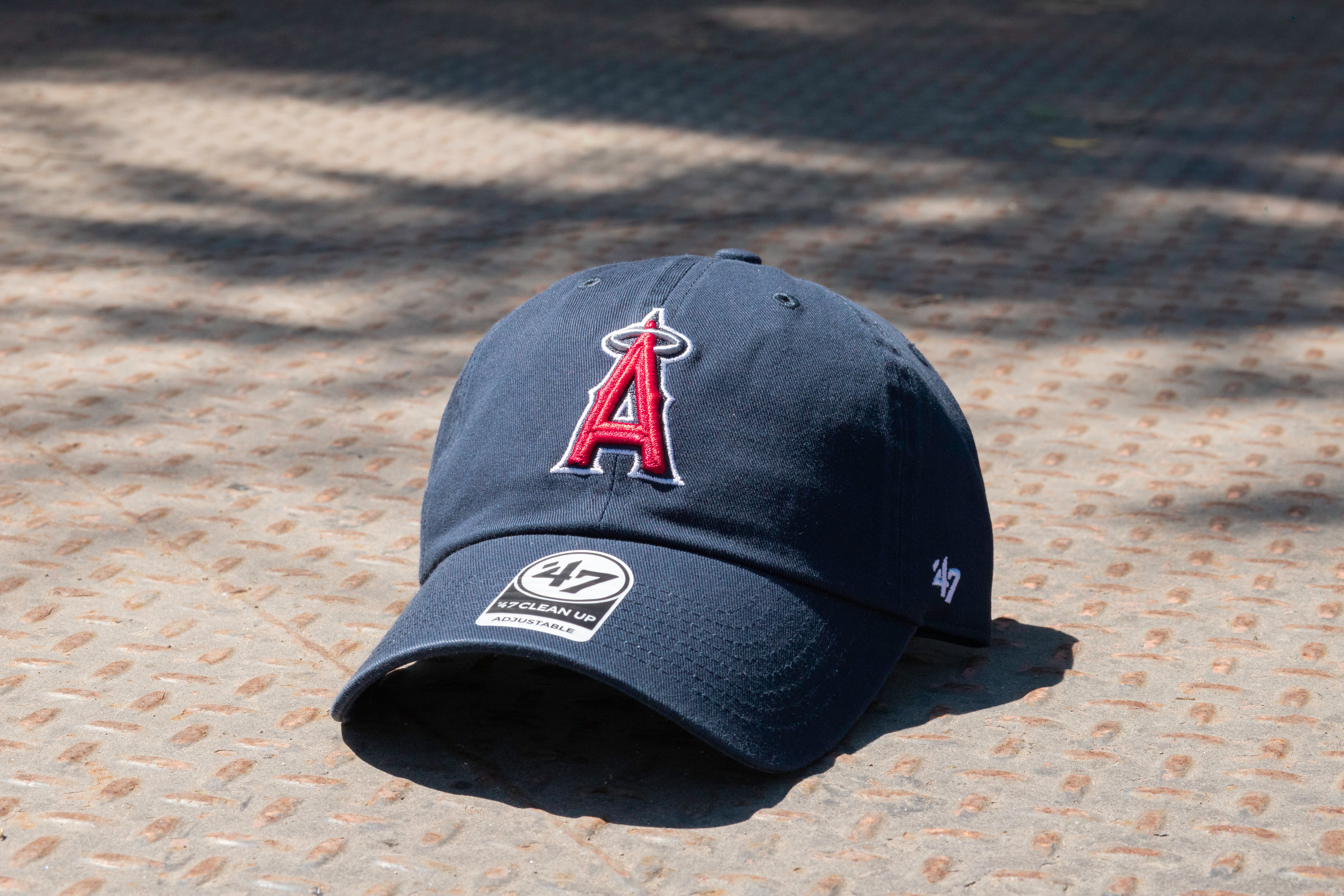 Navy blue baseball cap with a logo on a textured surface