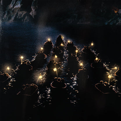 Candles floating on water in a dark cave