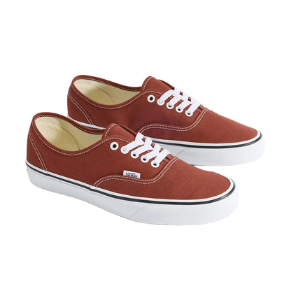 Pair of brown sneakers with white laces on a white background