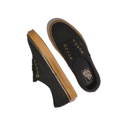 Black sneakers with tan soles on a white background