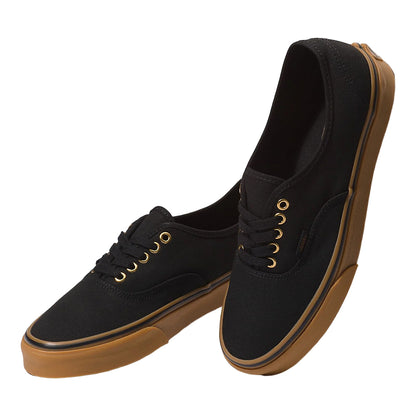 Black sneakers with brown soles on a white background