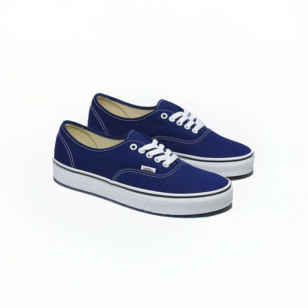 Pair of blue sneakers with white laces on a white background