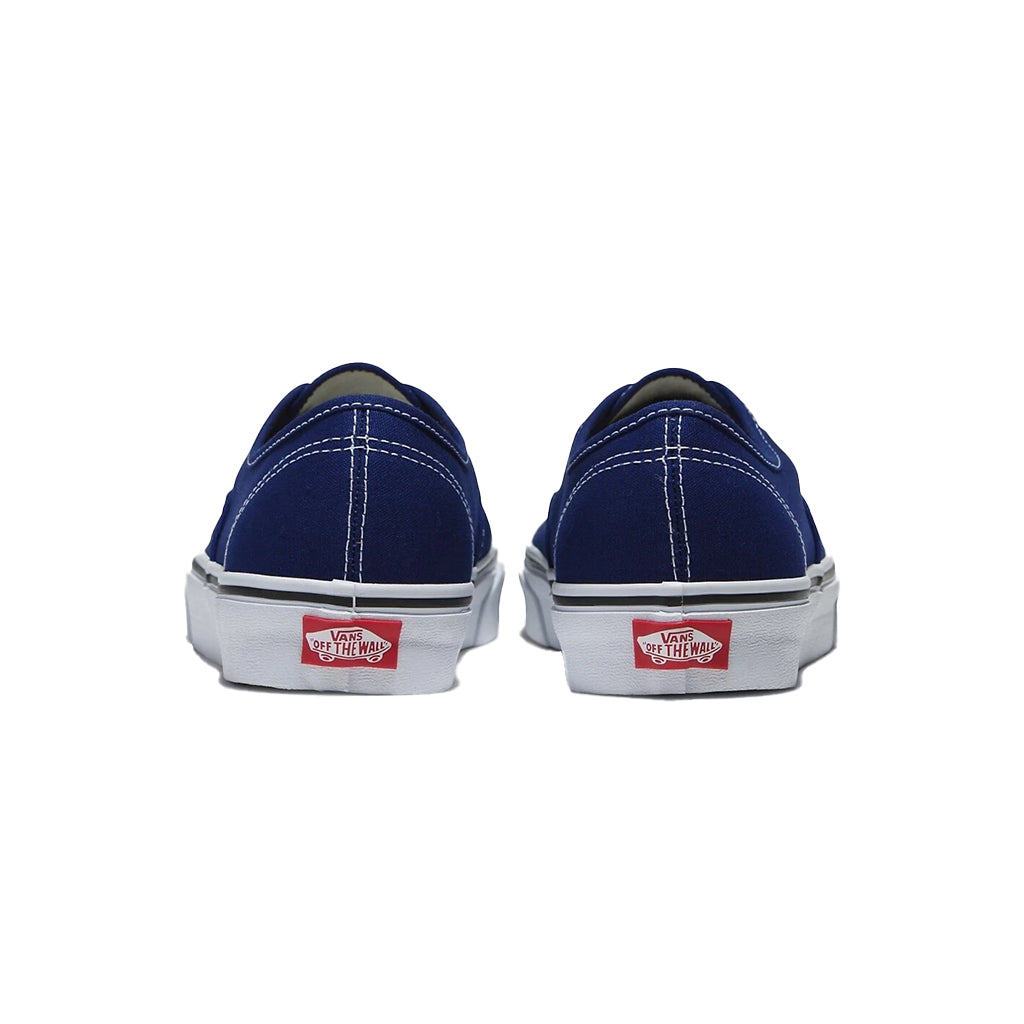 Pair of blue sneakers with red and white Vans logo on a white background