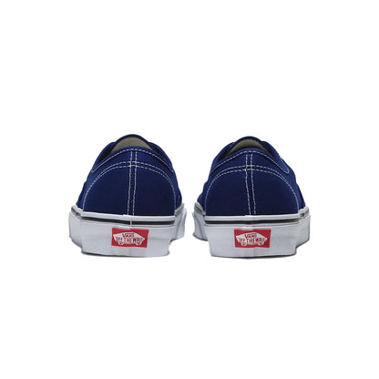Pair of blue sneakers with red and white Vans logo on a white background
