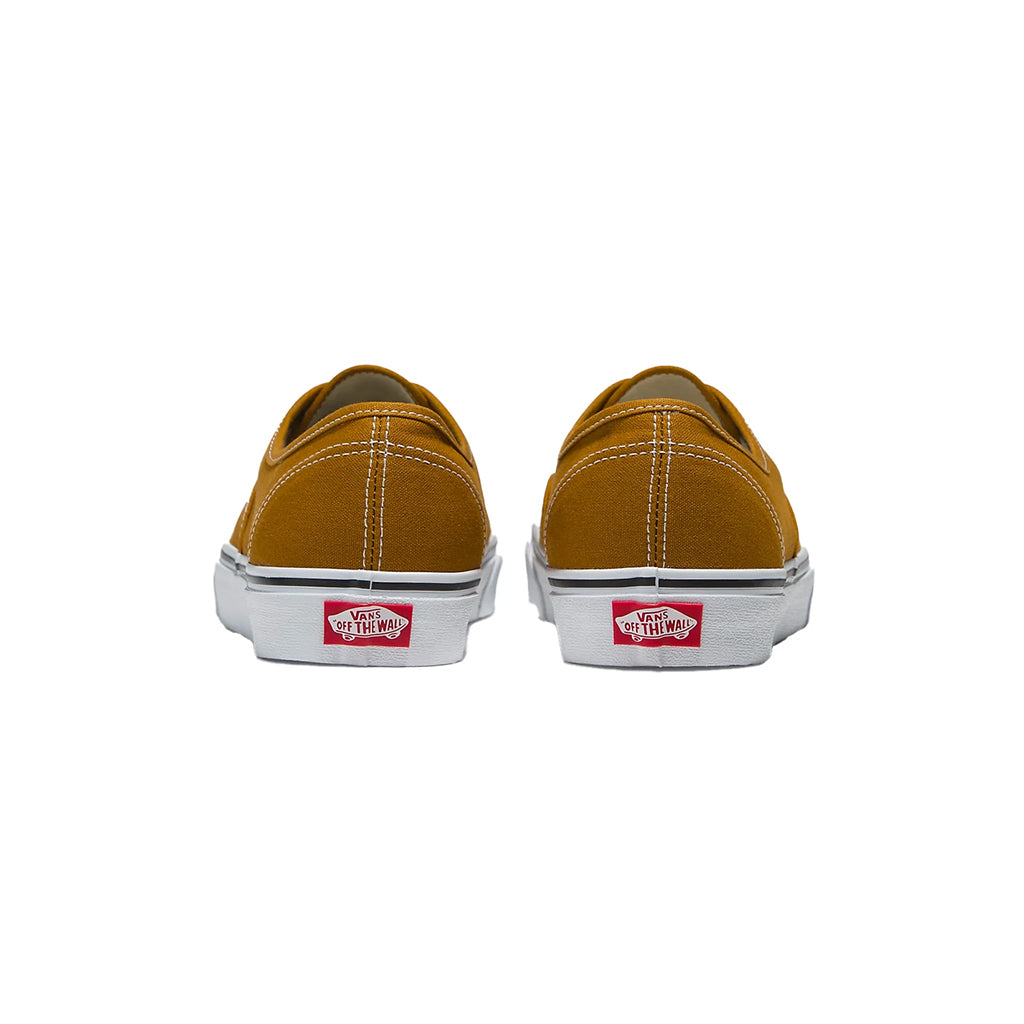 Pair of mustard yellow Vans sneakers on a white background