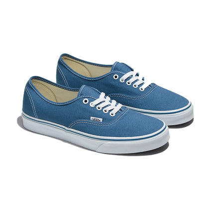 Pair of blue sneakers with white laces on a white background