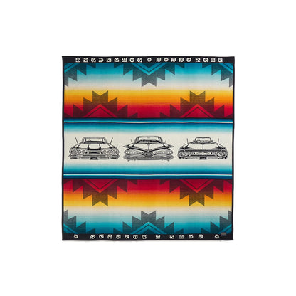Colorful blanket with geometric patterns and vintage car illustrations on a white background