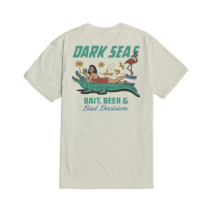 T-shirt with a graphic design featuring a woman on an alligator, text 'Dark Seas', and beach elements on a white background.