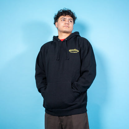 Person wearing a black hoodie with a logo on a blue background