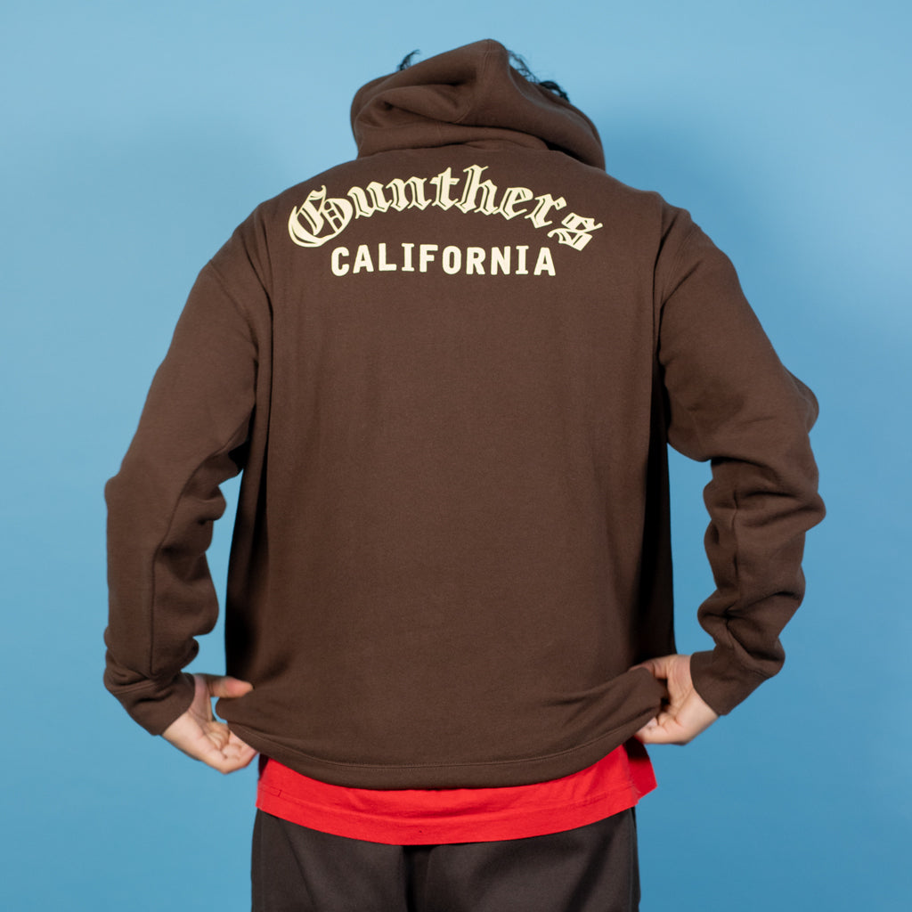 Brown hoodie with 'Gunthers California' text on the back against a blue background