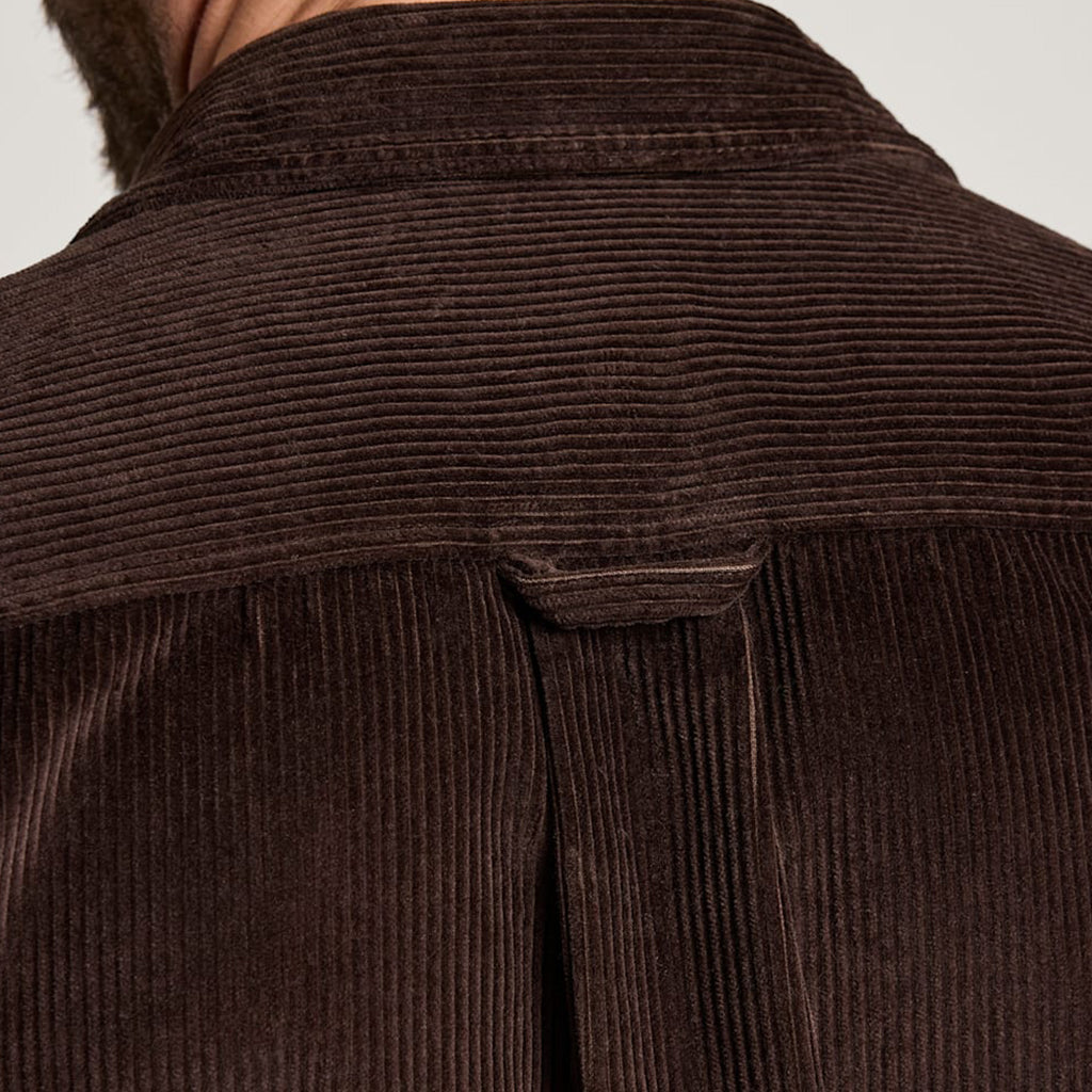 Close-up of a brown corduroy shirt with a collar on a light gray background