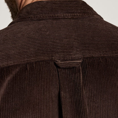 Close-up of a brown corduroy shirt with a collar on a light gray background