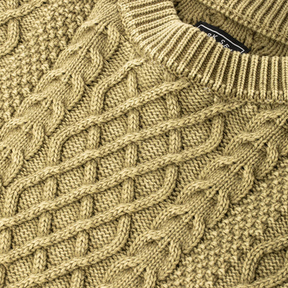 Close-up of a moss green knitted sweater with a brand label.