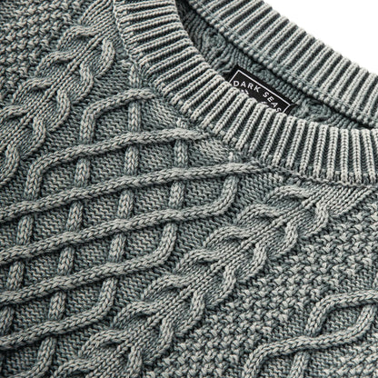 Close-up of a textured sweater with a brand label visible.