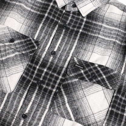 Close-up of a black and white plaid button-down shirt with two chest pockets and dark buttons.