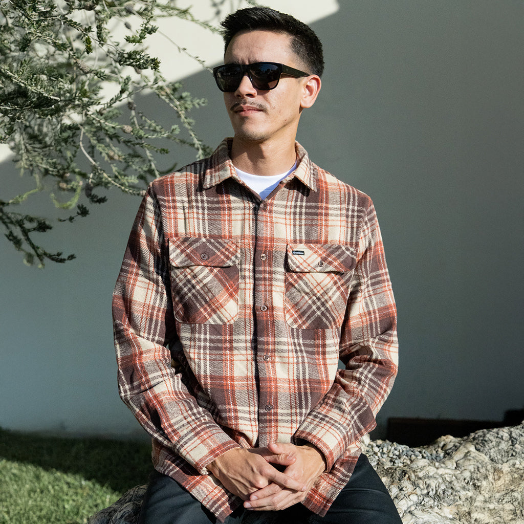 Man wearing a plaid shirt and sunglasses outdoors