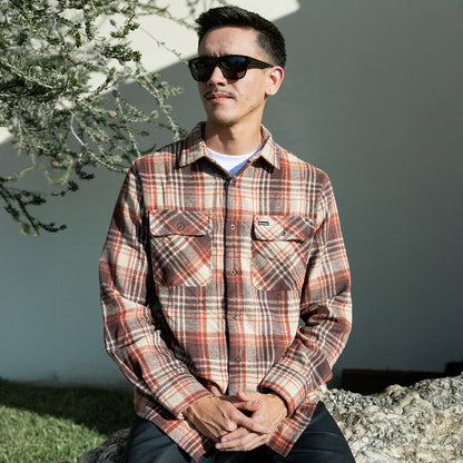 Man wearing a plaid shirt and sunglasses outdoors