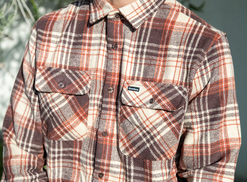 Plaid shirt with a visible brand logo on a blurred background