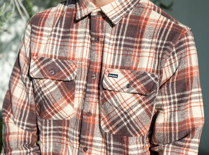 Plaid shirt with a visible brand logo on a blurred background