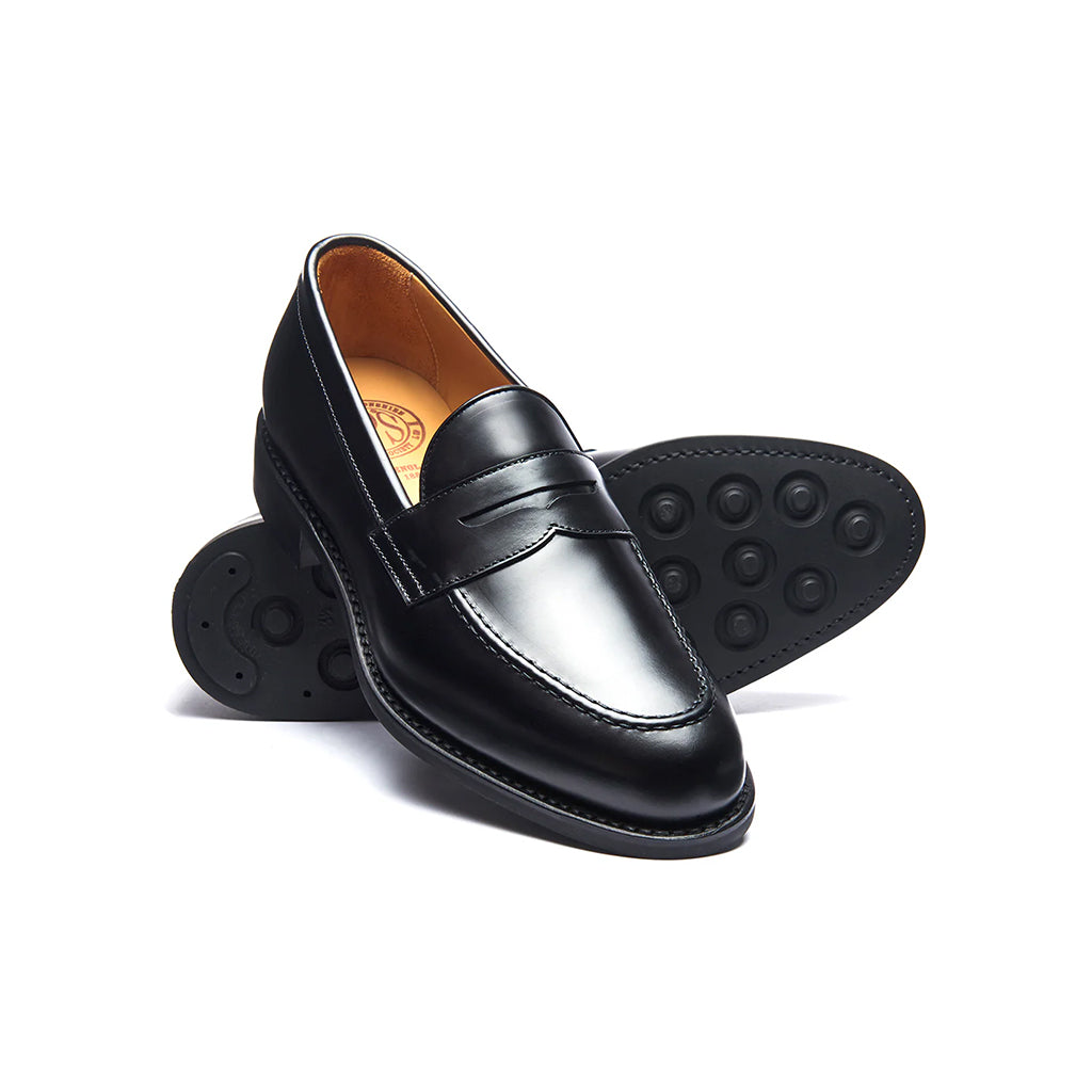 Black leather loafer shoes on a white background