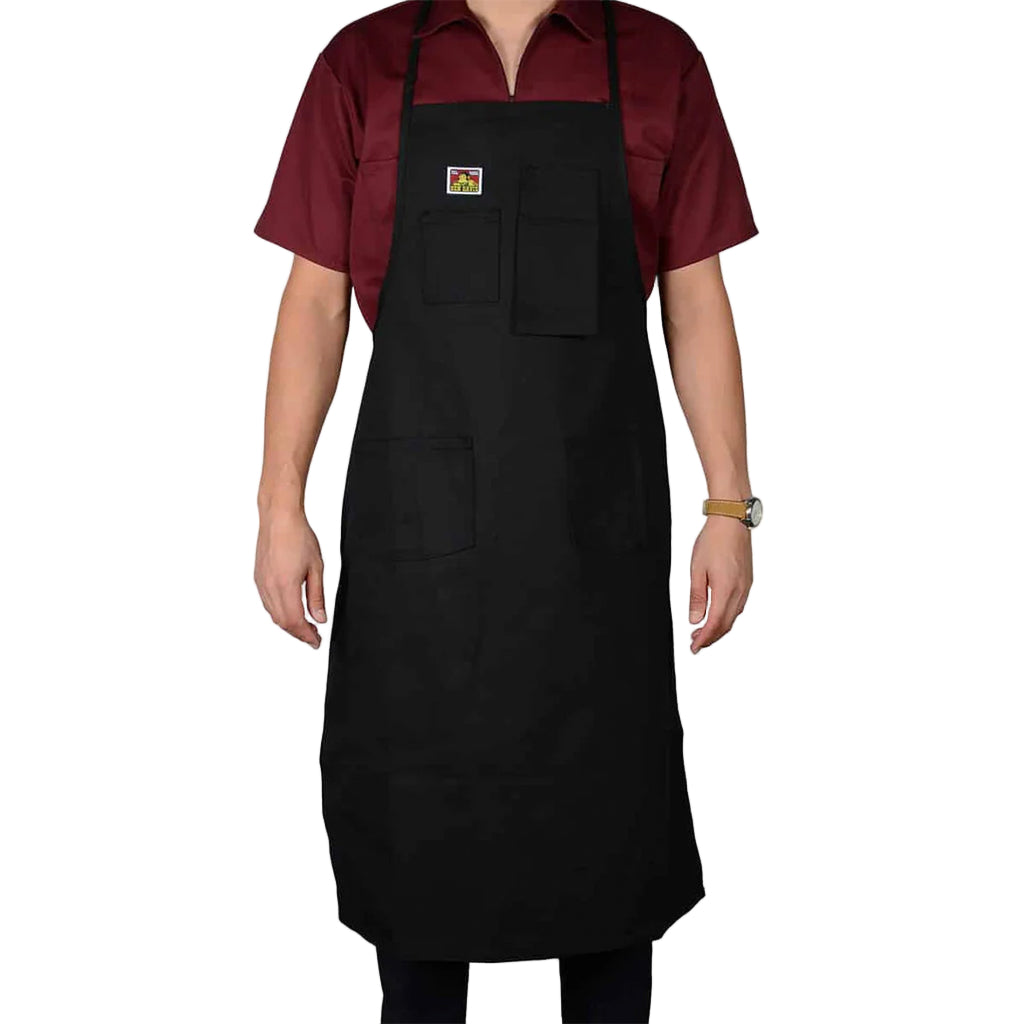 Person wearing a black apron over a red shirt on a white background