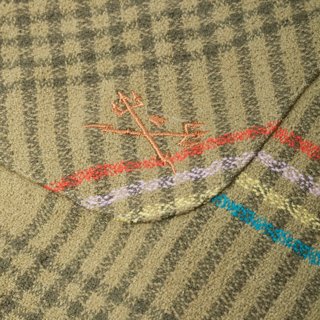 Close-up of a textured fabric with embroidered design on a green background