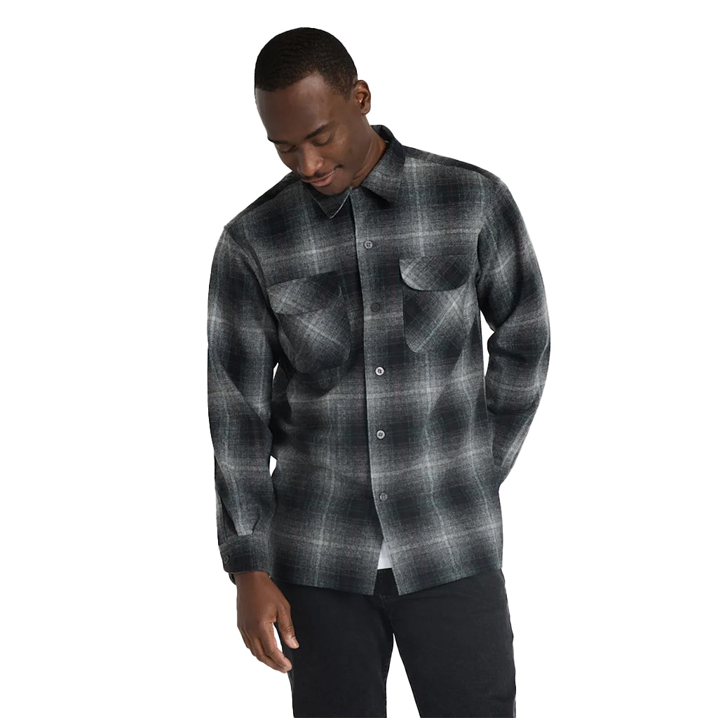 Man wearing a gray plaid shirt on a white background