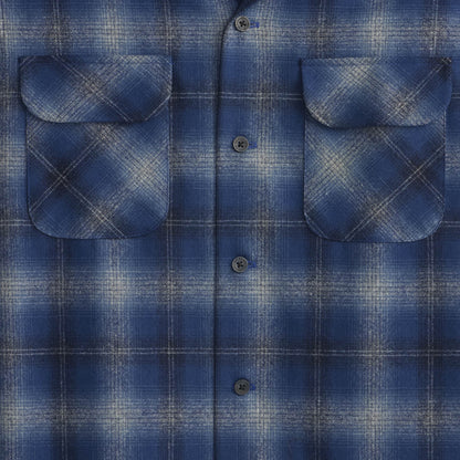 Close-up of a blue plaid shirt with two front pockets.
