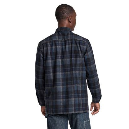 Man wearing a blue plaid shirt on a light gray background