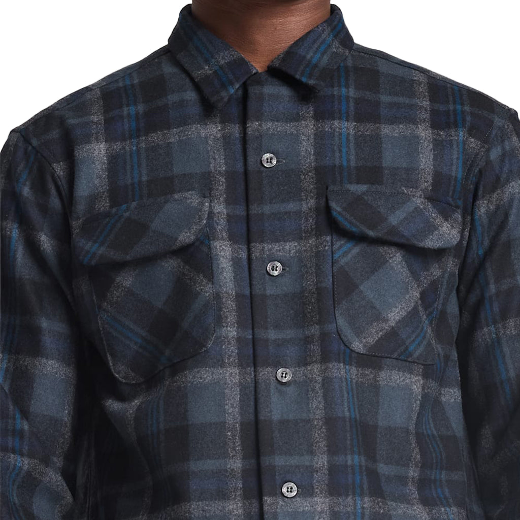 Close-up of a blue and gray plaid shirt with button details.