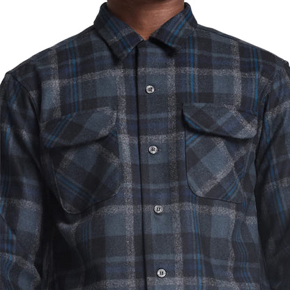 Close-up of a blue and gray plaid shirt with button details.