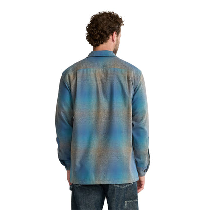 Man wearing a blue patterned shirt on a white background