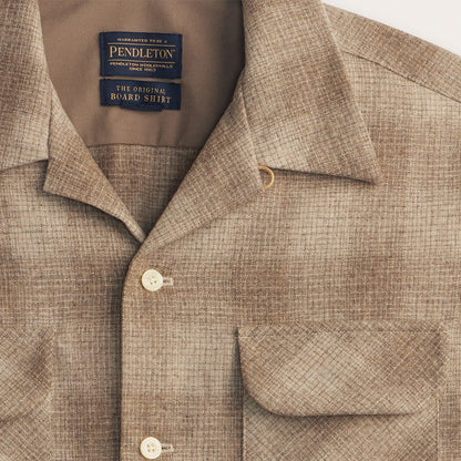 Close-up of a Pendleton shirt with a visible label on a beige background