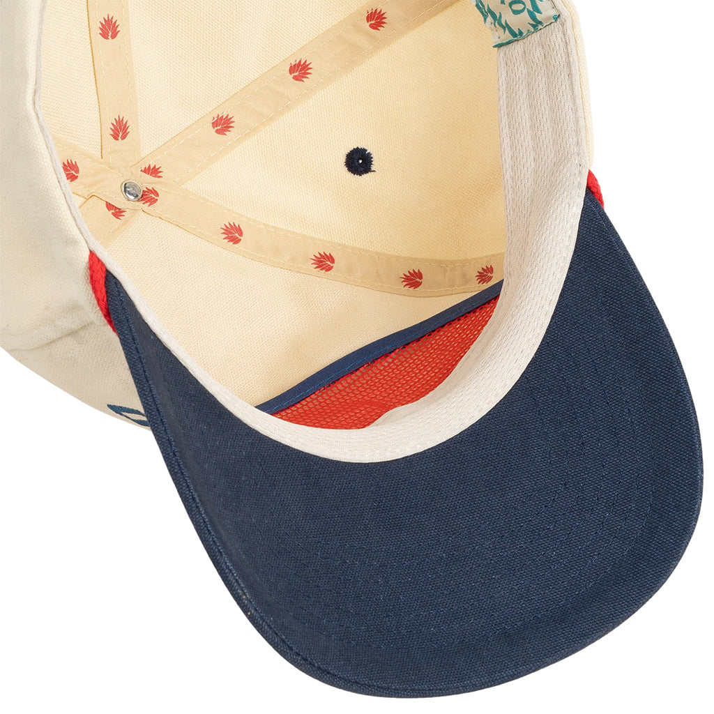Close-up of a cap with a blue brim and red interior on a white background