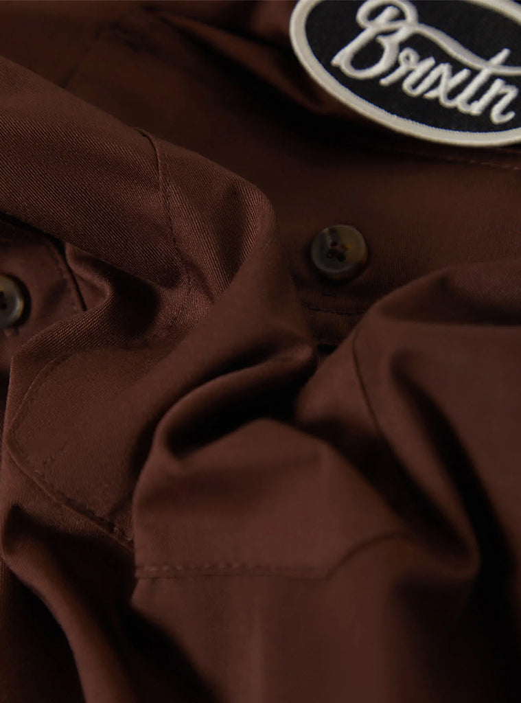 Brown jacket with a visible brand logo on a dark background