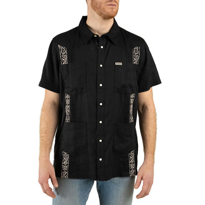Man wearing a black short-sleeve shirt with decorative patterns on a white background
