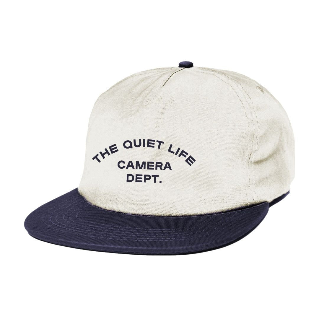 Beige and navy cap with 'The Quiet Life Camera Dept.' text on a white background