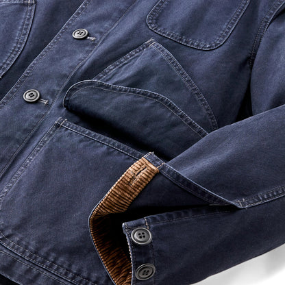 Close-up of a blue denim shirt with brown trim on a white background