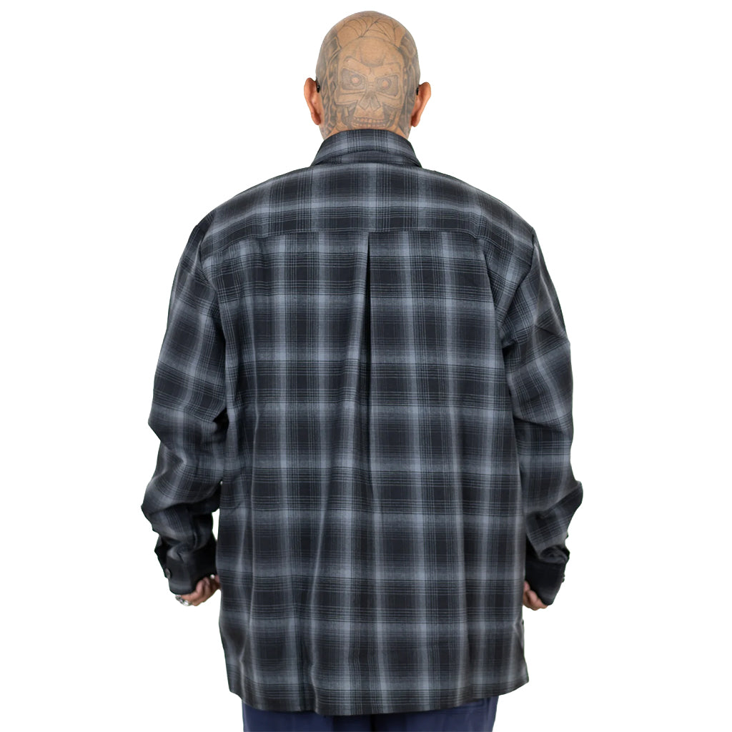 Person wearing a black and gray plaid shirt on a white background