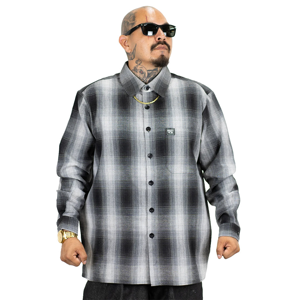 Man wearing a gray and black plaid shirt on a white background