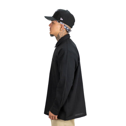 Person wearing a black jacket and cap on a white background